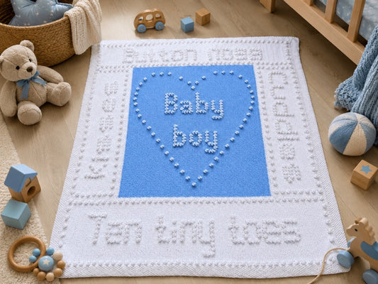 Ten Tiny Toes baby boy blanket knitting pattern displayed in a nursery with teddy bear, wooden toys and blue bobble stitch heart design