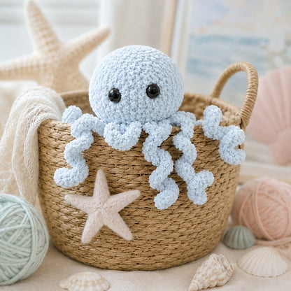 Soft baby blue jellyfish knitting pattern peeking from a wicker basket with seashells and pastel ocean nursery styling