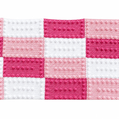 Crochet blanket made from pink and white puff stitch practice blocks
