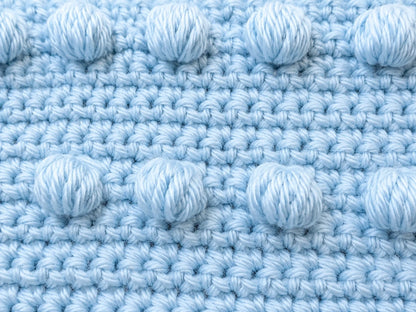 Close-up of crochet puff stitches and single crochet texture in a blue practice motif