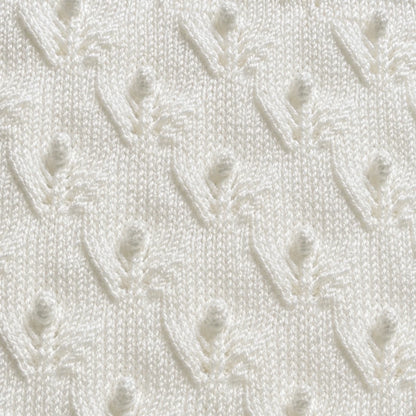 Elegant close up of white Budding Flowers baby blanket knitting pattern showing delicate floral lace and bobble stitch texture in soft ivory yarn