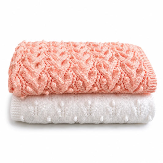 Folded peach and white baby blanket knitting pattern bundle with textured Plaited Bobbles and Budding Flowers stitch patterns on a white background with soft shadow