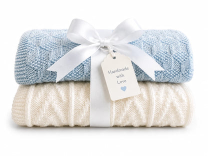 Gift wrapped blue and white baby blanket knitting pattern bundle with textured building blocks and chevron stitch patterns tied with a white ribbon and handmade tag on a white background
