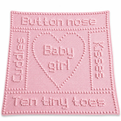 Button Nose Baby Girl blanket crochet pattern in soft pink displayed on a white background with a soft shadow.