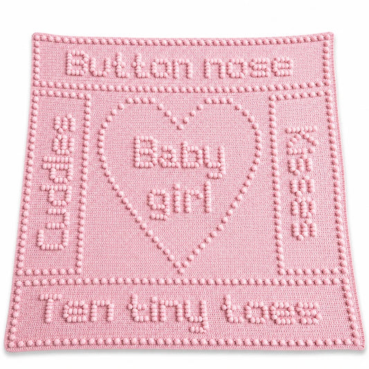 Button Nose Baby Girl blanket crochet pattern in soft pink displayed on a white background with a soft shadow.