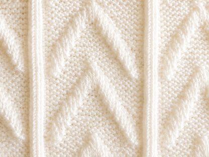 Elegant close up of white Chevrons baby blanket knitting pattern showing textured chevron knit and purl stitch detail