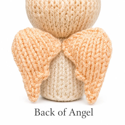 Back view of knitted angel Christmas decoration showing handmade wings and worked flat construction details.