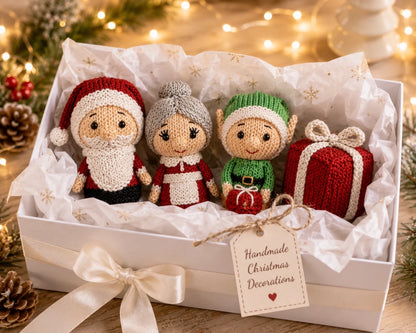 Knitted Santa, Mrs Claus, Elf and Present Christmas decorations displayed in a white gift box with tissue paper