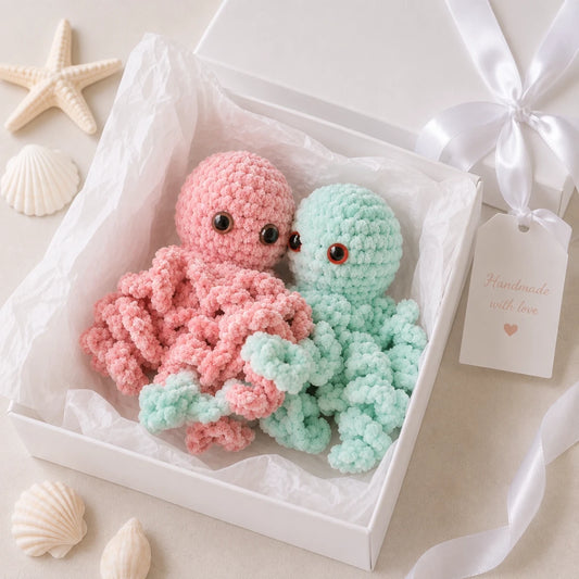 Soft pink and mint crochet jellyfish plush toys presented in a luxury white gift box with tissue paper and satin ribbon