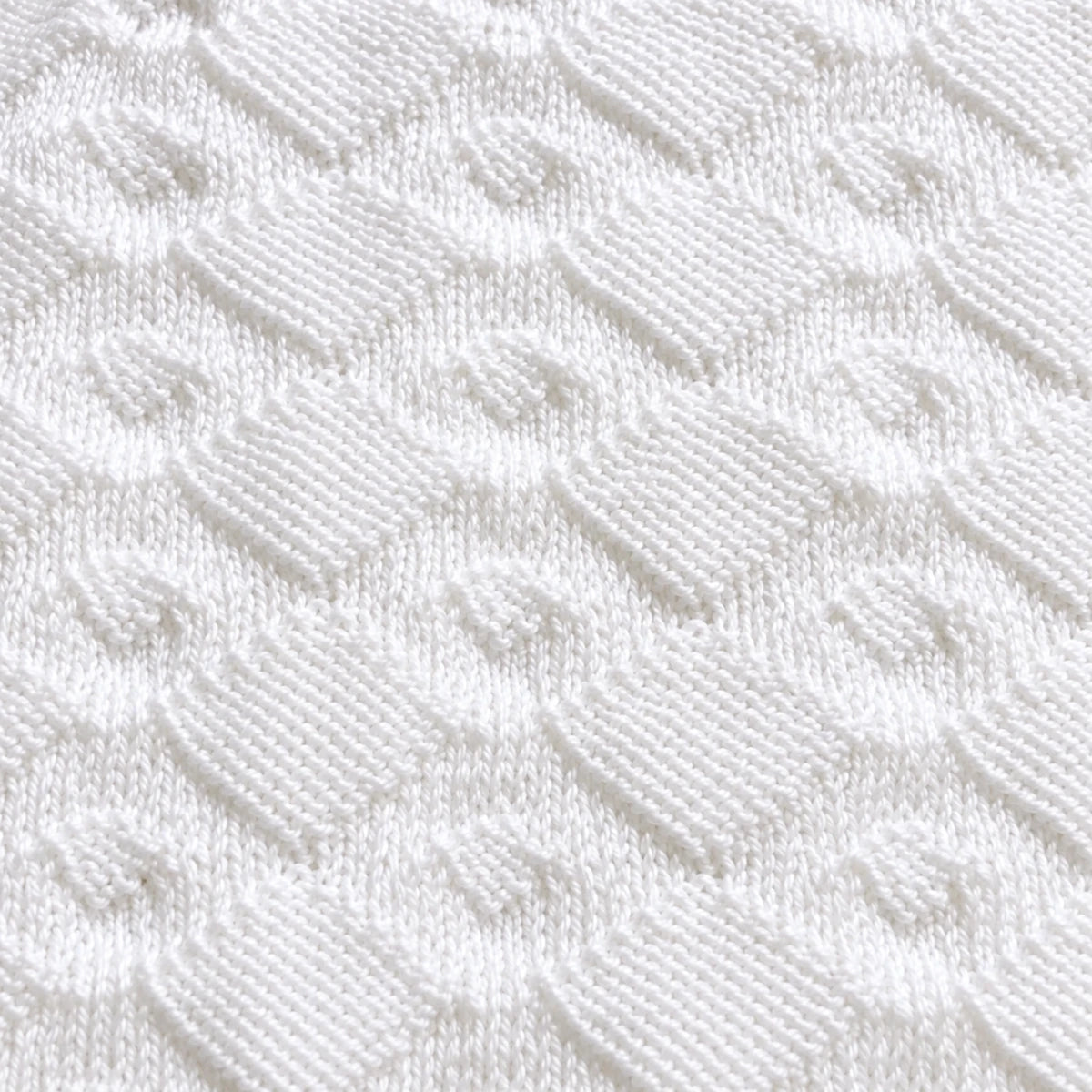 Close up texture of the Diamonds Are Forever baby blanket knitting pattern showing elegant white diamond stitch detail and soft knitted texture