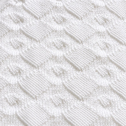Close up texture of the Diamonds Are Forever baby blanket knitting pattern showing elegant white diamond stitch detail and soft knitted texture