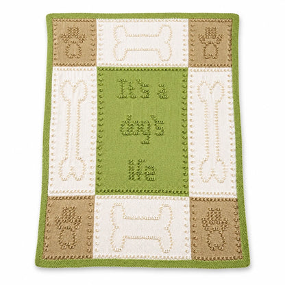 Dog Life baby blanket knitting pattern in green, cream and beige with paw print and bone motifs displayed on a white background with soft shadow.