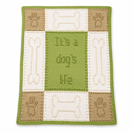 Dog Life baby blanket knitting pattern in green, cream and beige with paw print and bone motifs displayed on a white background with soft shadow.