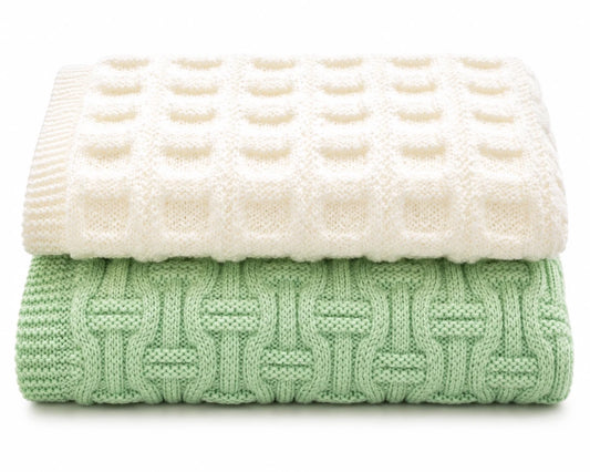 Easy baby blanket knitting pattern bundle featuring Framed Squares cream blanket and Snuggles mint green textured blanket folded on white background