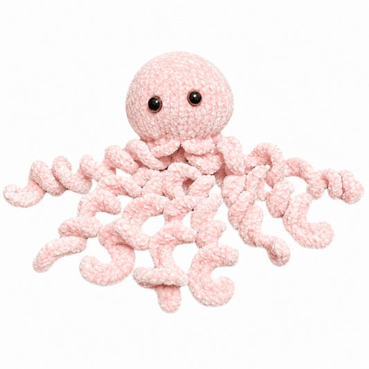 Soft pink knitted jellyfish plush toy made from fluffy yarn using the Peach Unicorn Designs free jellyfish knitting pattern.