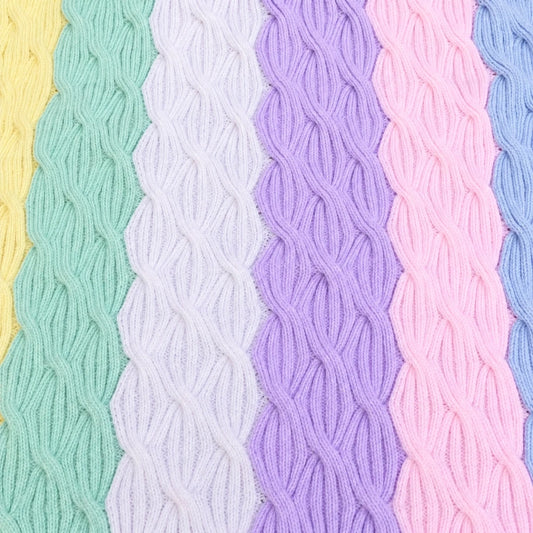 Close-up of Rainbow Waves baby blanket showing pastel cable knitting pattern in yellow, mint, lilac, purple, pink and blue stripes