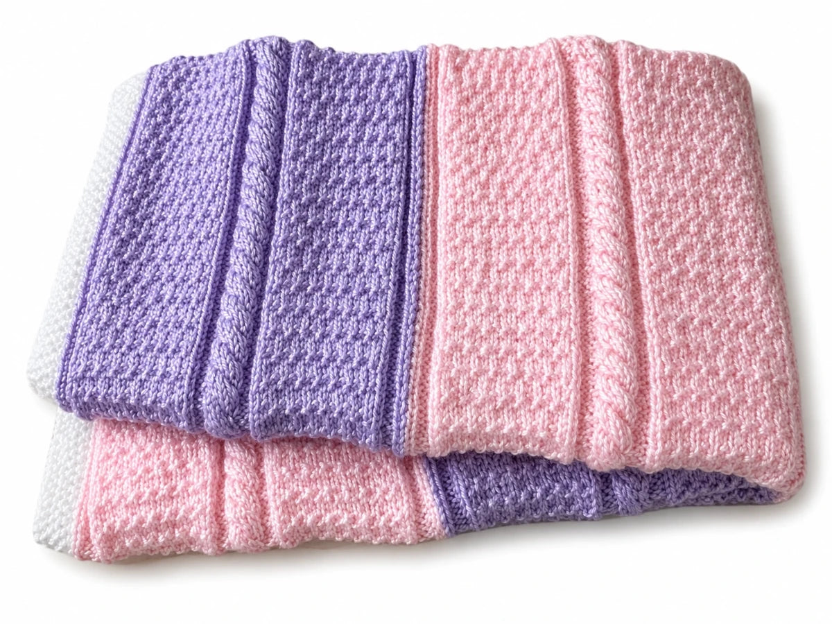 Folded purple and pink ganite Cable textured baby blanket on a white background