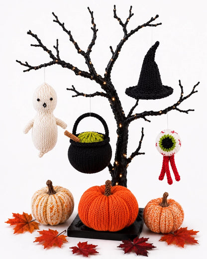 Knitted Halloween ornaments hanging from a decorative Halloween tree including ghost, cauldron, witch hat and eyeball decorations