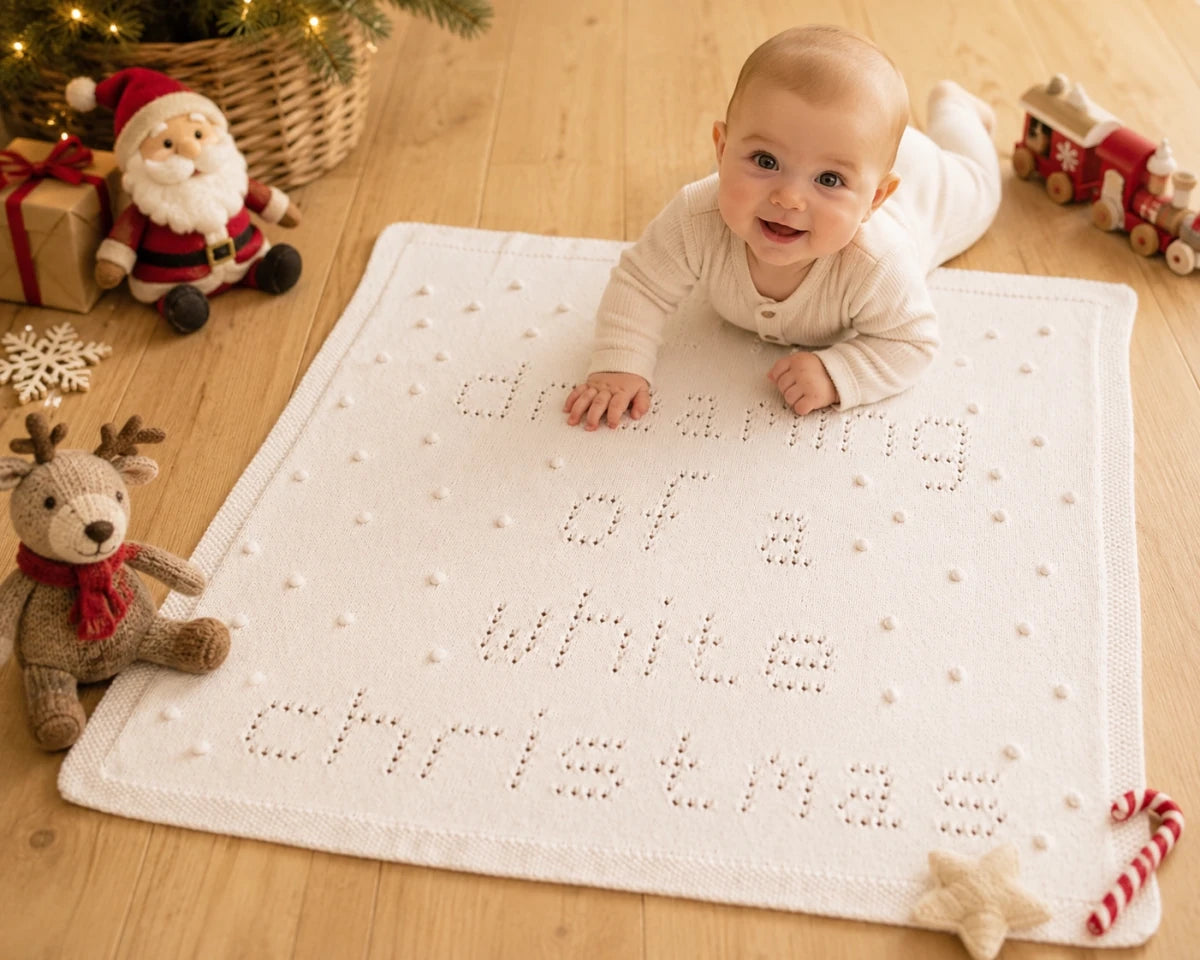 Baby enjoying tummy time on I'm Dreaming of a White Christmas baby blanket knitting pattern in a Christmas nursery