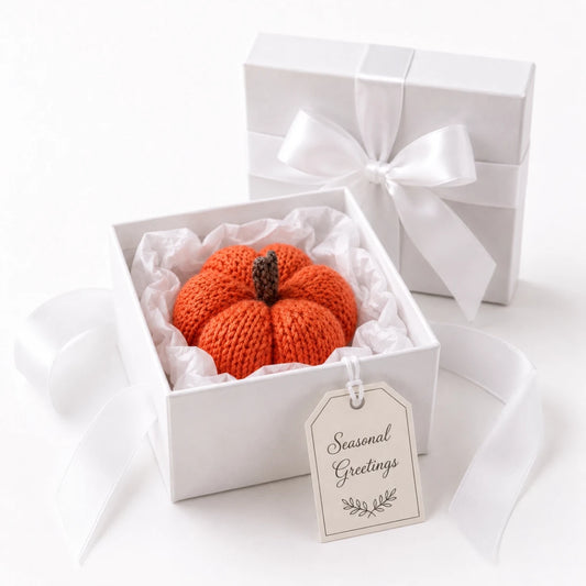 Knitted pumpkin Halloween decoration presented in a white gift box with tissue paper, white ribbon bow and Seasonal Greetings gift tag