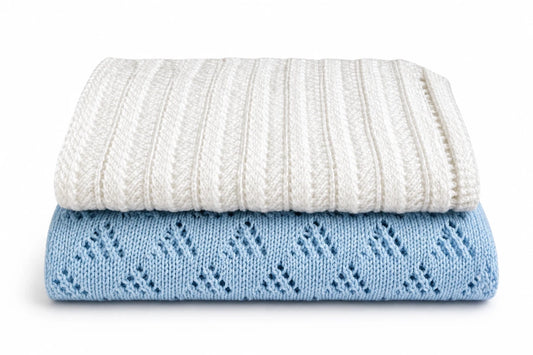 Folded white and blue lace baby blankets stacked together on a white background featuring the Lacy Lanes and Lacy Triangles knitting pattern bundle for beginners.
