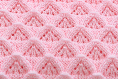 Elegant close up of pink Little Peaks baby blanket knitting pattern showing raised textured peak stitch detail in soft pastel yarn