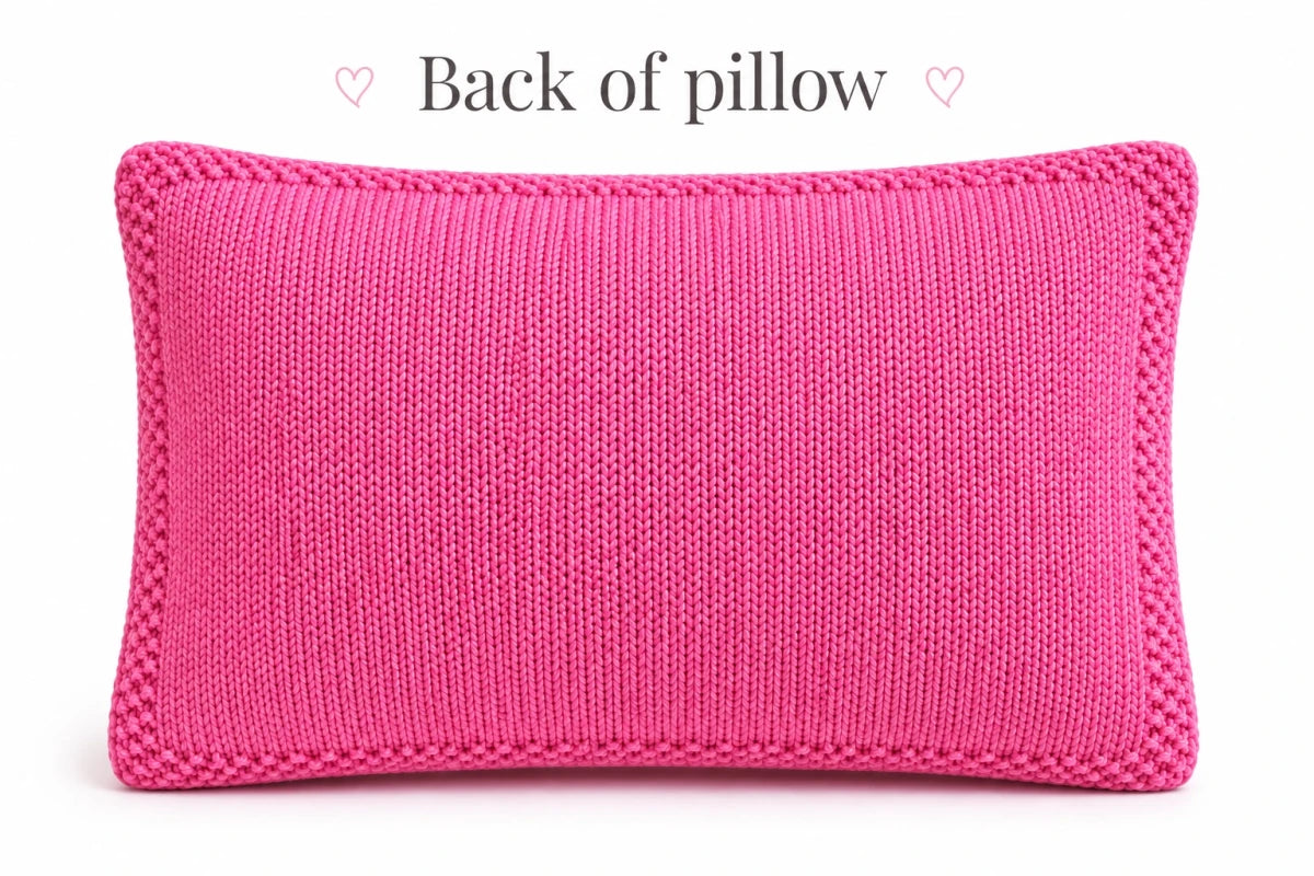 Back of pink LOVE pillow knitting pattern showing smooth stockinette stitch fabric with narrow seed stitch border around the cushion cover