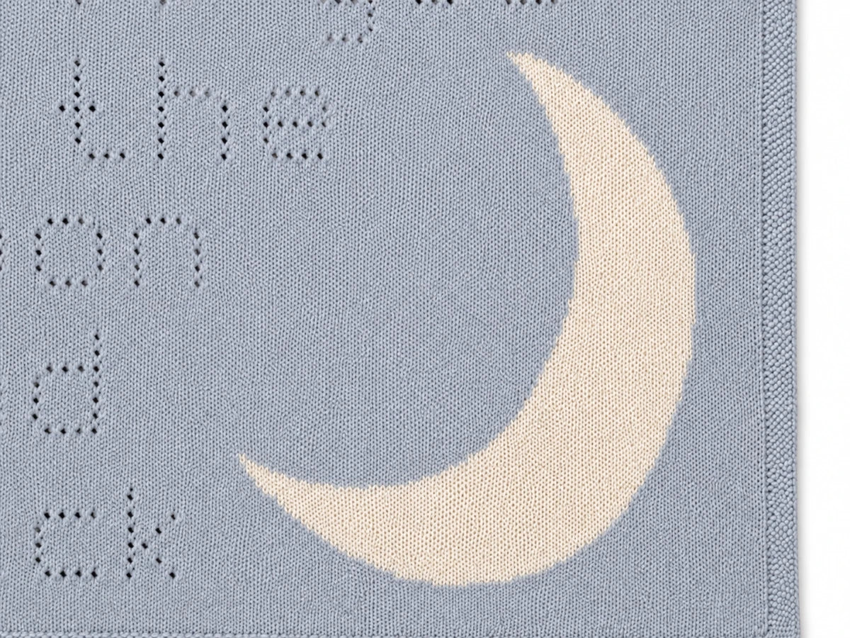 Close-up of the antique white moon motif on the Love You to the Moon and Back baby blanket knitting pattern showing stitch detail and texture