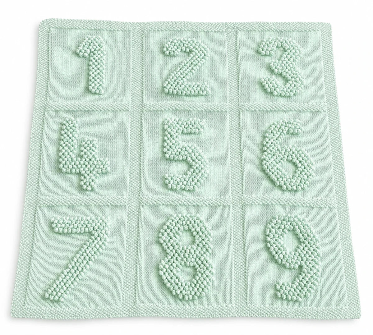 Soft baby green numbers baby blanket knitting pattern featuring bobble stitch numbers one to nine