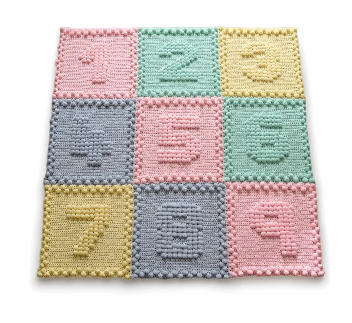 Pastel Numbers Motifs crochet baby blanket with raised puff stitch numbers on a white background.
