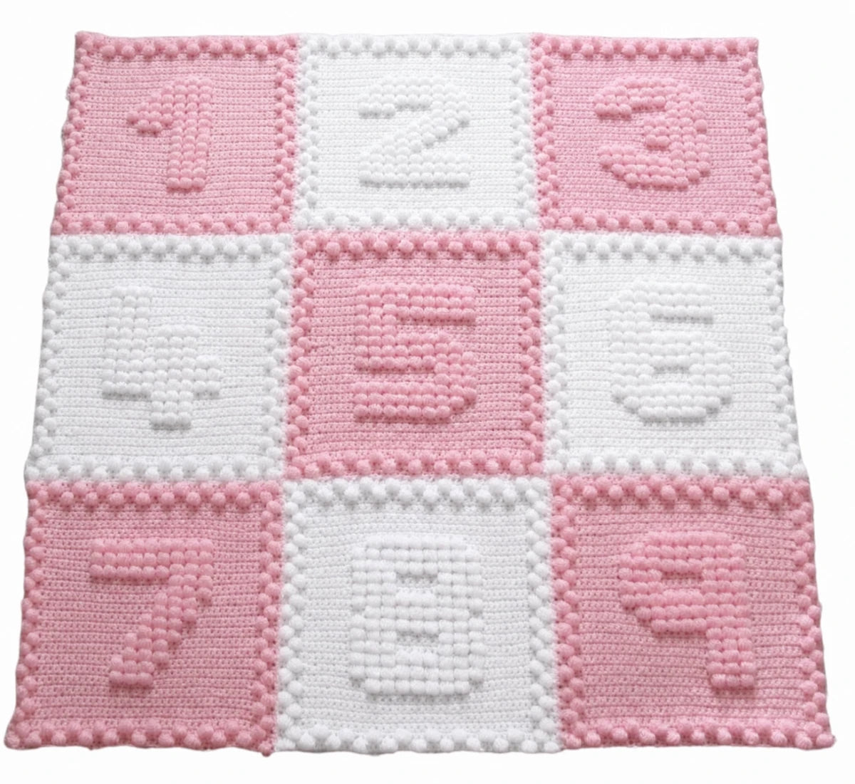 Pink and white Numbers Motifs crochet baby blanket featuring raised puff stitch numbers.