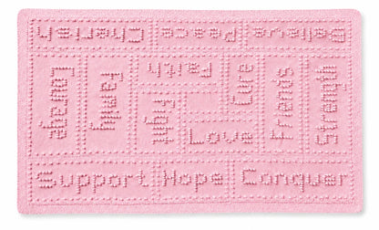 Soft pastel pink knitted cancer support lap blanket with comforting words and textured bobble stitch panels on a white background