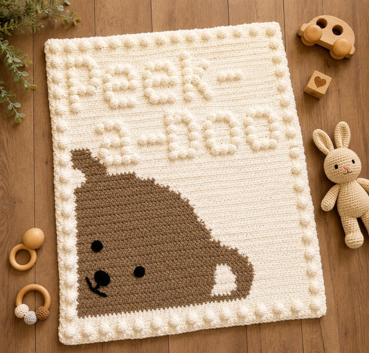 Peekaboo Baby Blanket crochet pattern displayed on a wooden nursery floor with natural wooden baby toys and soft greenery.