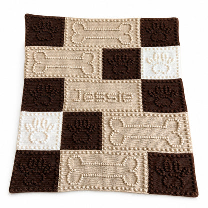 Personalised crochet dog blanket with paw prints bones and the name Jessie