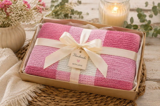 Folded pink gingham knitted baby blanket gift wrapped