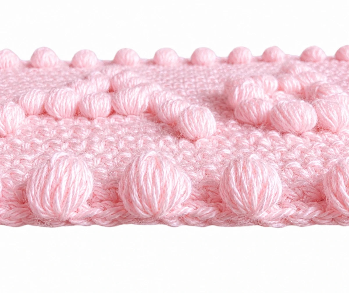 Close-up of soft pink puff stitch border and texture on the Precious One-Piece Baby Blanket crochet pattern.