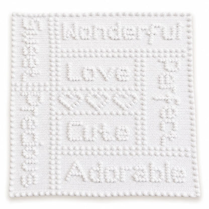 White Precious One-Piece Baby Blanket crochet pattern showing puff stitch wording, hearts and border on a white background.
