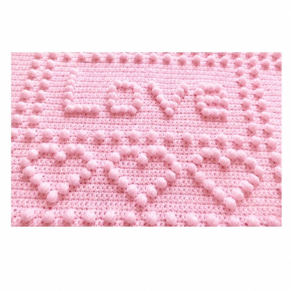 Close-up of the Love panel and puff stitch hearts on the soft pink Precious One-Piece Baby Blanket crochet pattern.
