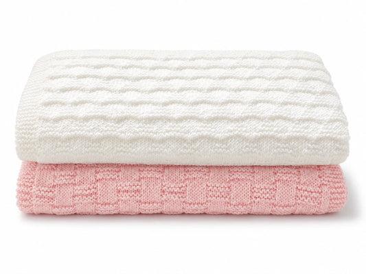 Folded white and pink baby blanket knitting pattern bundle with textured knit and purl stitch patterns on a white background with soft shadow