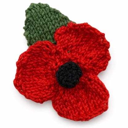 Hand knitted remembrance poppy with green leaf on a white background knitting pattern design