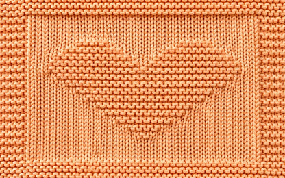 Close-up of the Simple Hearts Baby Blanket showing the garter stitch heart motif and textured knitted border
