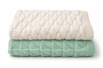 Folded white Dazzling Diamonds  baby blanket stacked on mint green  Simple Triangles baby blanket knitting pattern bundle on a white background