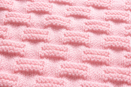 Elegant close up of soft pink Stepping Stones baby blanket knitting pattern showing raised knit and purl textured stitch detail