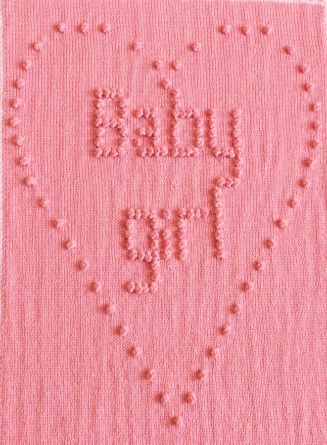 Close-up of Ten Tiny Toes baby blanket showing baby girl bobble stitch heart motif and textured lettering