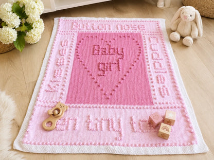 Ten Tiny Toes baby girl blanket knitting pattern displayed in a nursery with baby toys, bunny and white flowers
