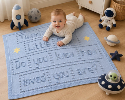 Baby enjoying tummy time on Twinkle Twinkle Little Star knitted baby blanket with space-themed nursery toys