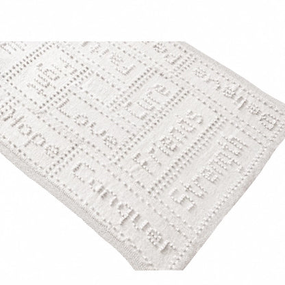 White knitted cancer support lap blanket with textured bobble stitch words and cream garter stitch border on a soft white background