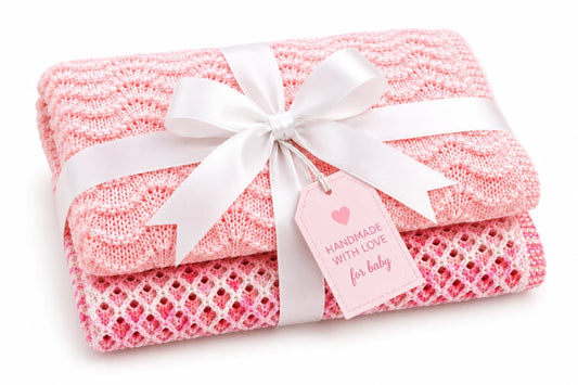 Gift wrapped Wiggly Curves and Gentle Waves baby blanket knitting pattern bundle with white satin ribbon and pink tag on a soft white background.