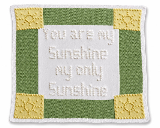 You Are My Sunshine baby blanket knitting pattern featuring bobble stitch wording, textured green panels and sunshine corner motifs