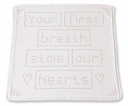 Your First Breath Stole Our Hearts baby blanket knitting pattern with lace lettering and heart details on a white background